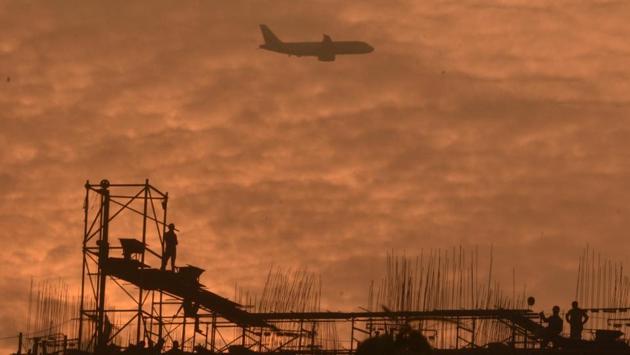 An airplane passes over workers on the site of an under construction building at Jogeshwari in Mumbai, Maharashtra (Pramod Thakur / HT Photo) An airplane passes over workers on the site of an under construction building at Jogeshwari in Mumbai, Maharashtra (Pramod Thakur / HT Photo)