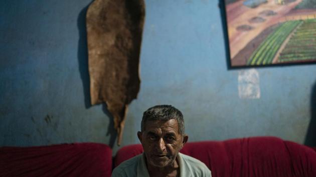“There was a dream of colonization, of getting land and seeing if here we could have better financial conditions,” Dedé Diniz, 69, said in his home. Diniz examined a photograph in his album, a shot of a truck trapped in mud. It’s nothing like the bucolic painting on his wall that shows farm furrows and wild forest beside the highway. He jokes that he’ll update the painting with asphalt soon — that stretch should be paved by 2021. (Leo Correa / AP)