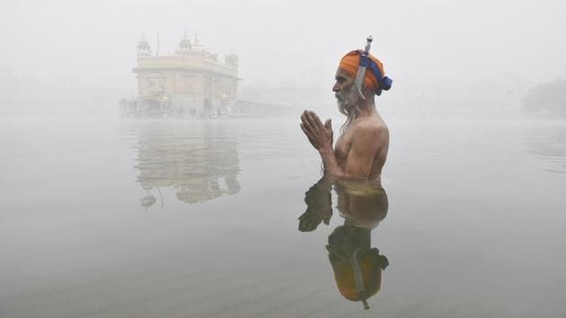 A Sikh devotee takes a dip in the sarover (water tank) on a foggy and cold day at the Golden Temple in Amritsar, Punjab. (Sameer Sehgal / HT Photo) A Sikh devotee takes a dip in the sarover (water tank) on a foggy and cold day at the Golden Temple in Amritsar, Punjab. (Sameer Sehgal / HT Photo)