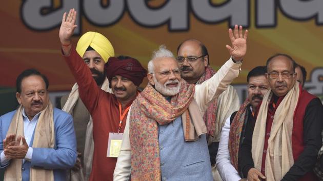 Prime Minister Narendra Modi waves at people during a rally at Ramlila Maidan in New Delhi on Sunday.(Burhaan Kinu/HT PHOTO.)