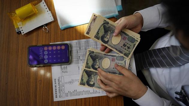 Norihito Arima counts cash he earned from his graveyard shift. Norihito has an MBA and speaks English fluently. For drivers who don’t, the company has a tablet to assist with language and a hotline for translation emergencies. Drivers can earn about 50,000-60,000 yen — about $450-550 — in a typical 18-hour shift. Drivers keep half and the company gets the other half. (Jae C. Hong / AP) 