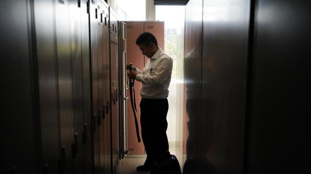 Norihito Arima takes off his tie after returning from his graveyard shift. Norihito acknowledged that when he started driving three years ago — he gave up a “boring office job” as a data analyst — he barely knew his way around Greater Tokyo, an area of about 35 million. “I couldn’t tell Shibuya from Shinjuku,” he said, despite passing a test that was much less rigorous than, say, London’s famous “The Knowledge” exam for taxi drivers. (Jae C. Hong / AP) 