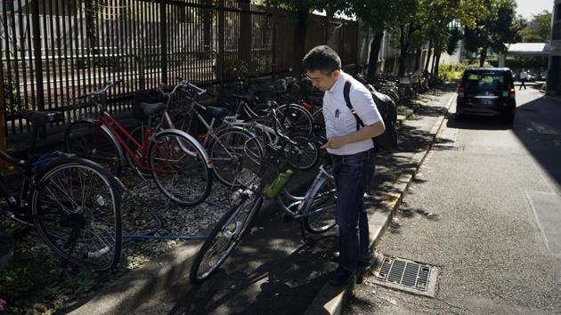 Norihito Arima grabs his bike as he leaves the company’s Akabane office after working his shift. “There is no easy job in Japan, but relatively I feel comfortable doing this job,” he said. “I like it because I can do it by myself. Sure, there are problems but I don’t need to get involved in office politics.” (Jae C. Hong / AP) 