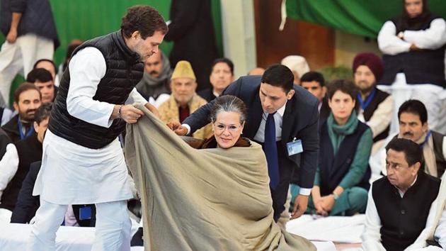 Congress MP Rahul Gandhi drapes a shawl around Congress interim President Sonia Gandhi during the sit in dharna against CAA and NRC, outside Rajghat, in New Delhi(Raj K Raj / Hindustan Times)