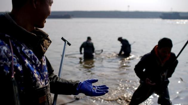 Fan Xinde holds a copper coin. As residents fled invading Japanese troops 80 years ago, the coins were packed into boxes and sent down the river on rafts, with many sinking without trace. They are now being unearthed as the water in the Poyang recedes to its lowest level in decades, providing a small income for fishermen like Fan facing an uncertain future. (Aly Song / REUTERS) Fan Xinde holds a copper coin. As residents fled invading Japanese troops 80 years ago, the coins were packed into boxes and sent down the river on rafts, with many sinking without trace. They are now being unearthed as the water in the Poyang recedes to its lowest level in decades, providing a small income for fishermen like Fan facing an uncertain future. (Aly Song / REUTERS)