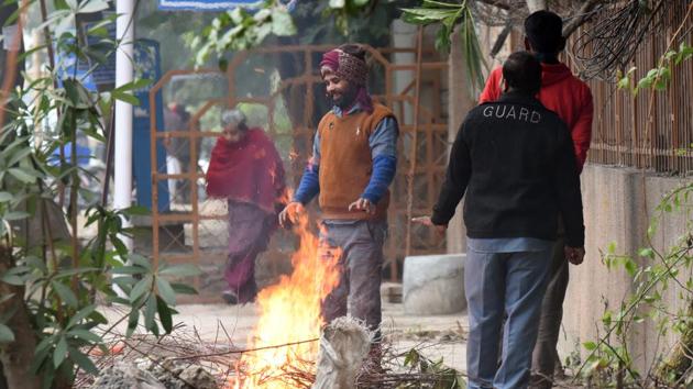 People warm themselves near a bonfire on a cold winter day, near Narwana road in New Delhi, on Monday. (Raj K Raj/HT Photo) People warm themselves near a bonfire on a cold winter day, near Narwana road in New Delhi, on Monday. (Raj K Raj/HT Photo)