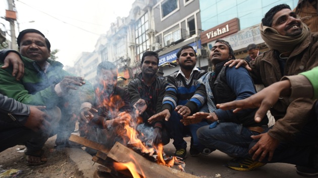 Labourers warm themselves around a bonfire on a cold winter morning, at Mahila colony Market in East Delhi on Tuesday, December 24.((Photo: Sonu Mehta/ Hindutsan Times))