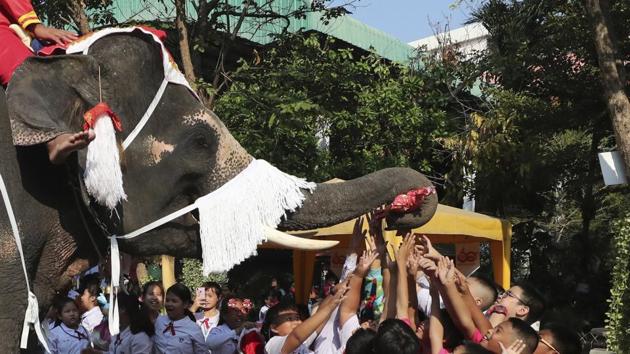 Bangkok: An elephant dressed in a Santa Claus costume offers gifts to children at the Jirasartwitthaya school during Christmas celebrations. (AP)
