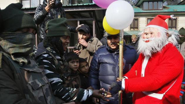 A man dressed as Santa Claus distributes candies to paramilitary soldiers outside the Holy Family Catholic church on Christmas in Srinagar, Jammu and Kashmir. The miniscule Christian population of Kashmir celebrated Christmas with traditional enthusiasm and religious fervour as the devotees thronged churches for mass as special prayers were held for peace in the Valley. (Mukhtar Khan / AP) A man dressed as Santa Claus distributes candies to paramilitary soldiers outside the Holy Family Catholic church on Christmas in Srinagar, Jammu and Kashmir. The miniscule Christian population of Kashmir celebrated Christmas with traditional enthusiasm and religious fervour as the devotees thronged churches for mass as special prayers were held for peace in the Valley. (Mukhtar Khan / AP)