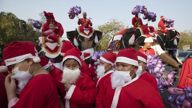 Students and elephants dressed in Santa Claus costumes offer gifts to students at Jirasartwitthaya school. (AP)