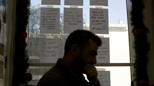 Words of encouragement are taped on a window next to Bassem, a volunteer, as he waits for calls at Lebanon’s Embrace. Atwi attributed the jump in calls received to the spike of media and public attention to the issue of suicide, something she said has saved lives. Calls even come from rural areas, not just Beirut. Atwi says the government has not given her organisation a toll-free number despite paying $25,000 a year for the four-digit helpline. (Maya Alleruzzo / AP) Words of encouragement are taped on a window next to Bassem, a volunteer, as he waits for calls at Lebanon’s Embrace. Atwi attributed the jump in calls received to the spike of media and public attention to the issue of suicide, something she said has saved lives. Calls even come from rural areas, not just Beirut. Atwi says the government has not given her organisation a toll-free number despite paying $25,000 a year for the four-digit helpline. (Maya Alleruzzo / AP)