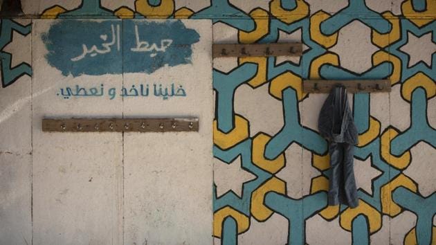 A lone pair of trousers hangs on the “Wall of Kindness,” as the words “Let us give and take” are seen in Arabic. Here, people can leave clothes or other items for those in need. To extend their support, stores have offered discounts and set up boxes for donations of clothes or money. (Maya Alleruzzo / AP) A lone pair of trousers hangs on the “Wall of Kindness,” as the words “Let us give and take” are seen in Arabic. Here, people can leave clothes or other items for those in need. To extend their support, stores have offered discounts and set up boxes for donations of clothes or money. (Maya Alleruzzo / AP)