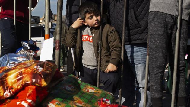 A little boy waits for a Christmas present as protesters distribute gifts to the needy at Martyrs' Square. WhatsApp groups and Instagram pages shared addresses of small local businesses for shoppers to use for Christmas gifts. “We are all in this together,” said one tag line. (Maya Alleruzzo / AP) A little boy waits for a Christmas present as protesters distribute gifts to the needy at Martyrs' Square. WhatsApp groups and Instagram pages shared addresses of small local businesses for shoppers to use for Christmas gifts. “We are all in this together,” said one tag line. (Maya Alleruzzo / AP)