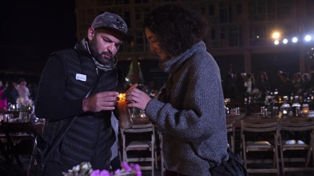 Volunteers light a candle for a table set for a public Christmas dinner at Martyrs’ Square. (Maya Alleruzzo / AP) Volunteers light a candle for a table set for a public Christmas dinner at Martyrs’ Square. (Maya Alleruzzo / AP)