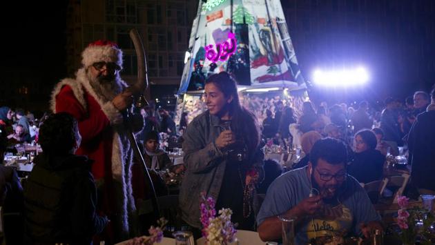 A volunteer, centre, serves drinks at a public Christmas dinner as a boy asks Santa Claus for a selfie. “We only have each other” proclaims the campaign’s hashtag. (Maya Alleruzzo / AP) A volunteer, centre, serves drinks at a public Christmas dinner as a boy asks Santa Claus for a selfie. “We only have each other” proclaims the campaign’s hashtag. (Maya Alleruzzo / AP)