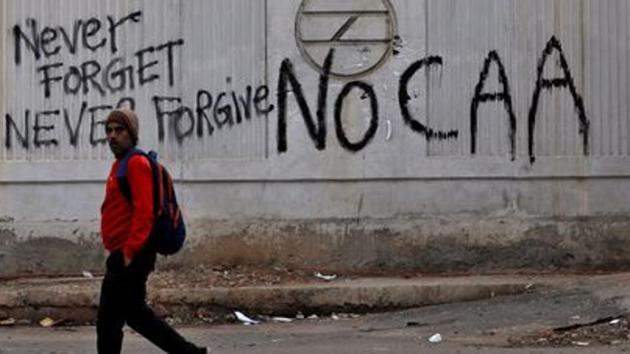 A man walks past a graffiti during a protest against a new citizenship law.(Reuters file photo)