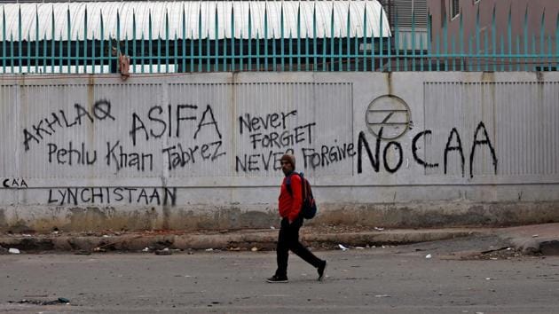 A man walks past a graffiti at Shaheen Bagh. (Anushree Fadnavis / REUTERS)