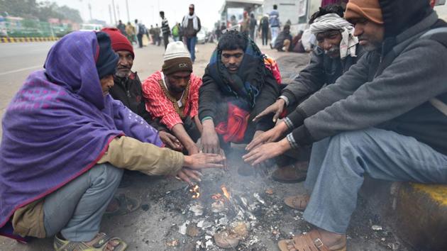 People sit around a bonfire to warm themselves on a cold winter day, at AIIMS, in New Delhi, India, on Wednesday, December 25, 2019.(Sanchit Khanna/HT PHOTO)