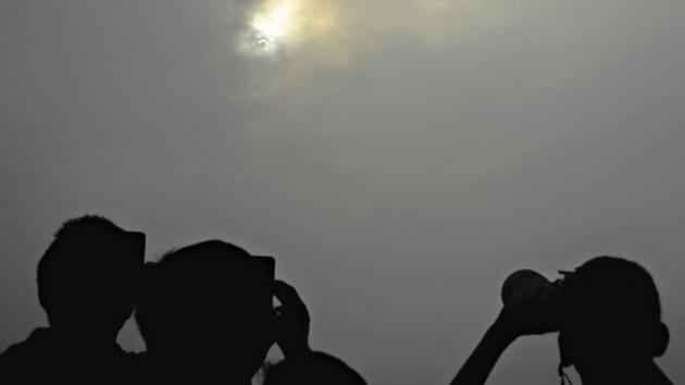 Clouds did not affect the enthusiasm of residents who were determined to bust the superstitions surrounding the solar eclipse. (MILIND SAURKAR/HT) Clouds did not affect the enthusiasm of residents who were determined to bust the superstitions surrounding the solar eclipse. (MILIND SAURKAR/HT)
