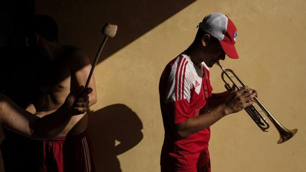 A member of Red Demons plays the trumpet before a soccer game match between Deportivo Lara and Caracas FC at Estadio Metropolitano in Cabudare. During the political confrontation that is gripping Venezuela, it is common for the news to highlight the polarisation between supporters of socialist President Nicolás Maduro and those of the opposition, led by Juan Guaidó. (Matias Delacroix / AP)