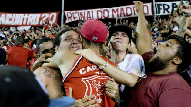 Red Demons Vanderlei Rojo, left, and Moises Diaz hug after their team won the national league’s final championship soccer match against Estudiantes de Merida at Estadio Olimpico in Caracas. While watching the game,the fans get past their political differences and scream, jump and sing as one, while beating their chests in unison. (Matias Delacroix / AP)