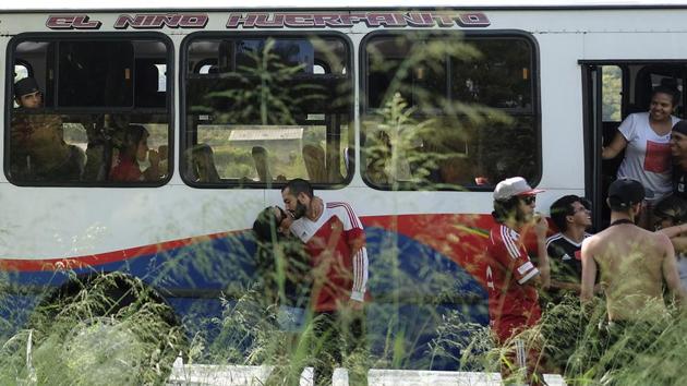Members of the Caracas FC fan club Vanessa Estrella and John Rada, kiss as their bus stops for a break in Valencia as they travel to Cabudare for a soccer match between Deportivo Lara and Caracas FC. The passion of Red Demons did not lessen in the decade that their team was performing poorly, and that loyalty finally paid off when they became champion of the Venezuela League. (Matias Delacroix / AP)