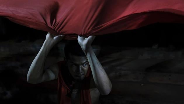 A member of Red Demons holds the edge of a giant banner before the final championship match of the national league. The fans now expect more victories, and they hope to continue growing and striving to offer a positive image whenever they can. (Matias Delacroix / AP)