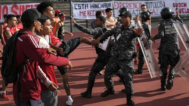Fans of the Caracas FC soccer team clash with National Police officers before a game at Estadio Olimpico in Caracas. Clashes broke out when fans refused to put away banners that were considered offensive. (Matias Delacroix / AP)
