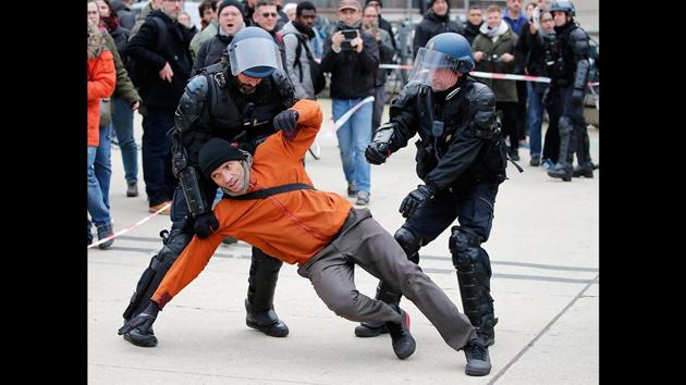 Riot police officers detain a striking train worker outside the the Gare de Lyon train station in Paris, France, on December 23. A wildcat protest comes on Day 19 of nationwide strike over the government's plans to raise the retirement age to 64. (Francois Mori / AFP) Riot police officers detain a striking train worker outside the the Gare de Lyon train station in Paris, France, on December 23. A wildcat protest comes on Day 19 of nationwide strike over the government's plans to raise the retirement age to 64. (Francois Mori / AFP)