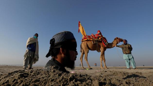 Mehrban Akhtar, 20, blindfolded and buried up to his neck in sand during a solar eclipse, is pictured along Clifton beach in Karachi, Pakistan. Many Pakistanis believe that burying people with disabilities in sand during solar eclipse would bring healing to their bodies. (Akhtar Soomro / REUTERS) Mehrban Akhtar, 20, blindfolded and buried up to his neck in sand during a solar eclipse, is pictured along Clifton beach in Karachi, Pakistan. Many Pakistanis believe that burying people with disabilities in sand during solar eclipse would bring healing to their bodies. (Akhtar Soomro / REUTERS)