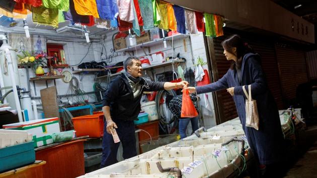 Fish seller Lai Ji serves a customer at his stall in a fish market at North Point. "The outside has changed but everything inside is still the same, even the position of our stalls, the same for 80 years", Ji said. Asked about the protests he said: "We built everything just so they [the protesters] could destroy it all. Here in Hong Kong the elderly have a place to live, food to eat and medical care. Hong Kong is very free." (Thomas Peter / REUTERS) 