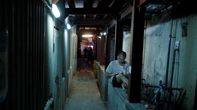 A man smokes a cigarette in an alley near the Chun Yeung Street wet market at North Point. Largely strangers months ago, the new councillors now meet regularly to discuss how they are going to shake up Hong Kong politics. (Thomas Peter / REUTERS) A man smokes a cigarette in an alley near the Chun Yeung Street wet market at North Point. Largely strangers months ago, the new councillors now meet regularly to discuss how they are going to shake up Hong Kong politics. (Thomas Peter / REUTERS)