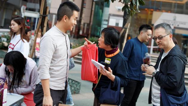 Locals line up to write Christmas cards to protesters in detention and get free calendars and chocolate that are Christmas gifts from incoming district councillors Tat Cheng (3rd from left) and Lee Yue-Shun (2nd from right) at North Point. “The community is not separated by different constituencies so we have to do the work together," said Yue-Shun, who won the the Kam Ping constituency. (Thomas Peter / REUTERS) Locals line up to write Christmas cards to protesters in detention and get free calendars and chocolate that are Christmas gifts from incoming district councillors Tat Cheng (3rd from left) and Lee Yue-Shun (2nd from right) at North Point. “The community is not separated by different constituencies so we have to do the work together," said Yue-Shun, who won the the Kam Ping constituency. (Thomas Peter / REUTERS)