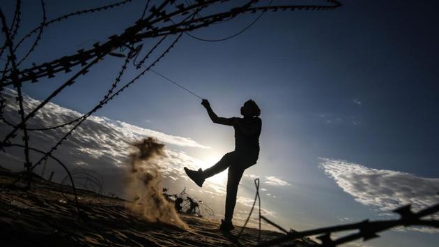 A Palestinian protester uses a sling to hurl stones at Israeli troops at the Israel-Gaza border fence, east of Rafah in the southern Gaza Strip. Hundreds of Palestinians took part in protests along the Gaza-Israel border on December 27, the last of the Hamas-backed demonstrations until March. (Said Khatib / AFP) A Palestinian protester uses a sling to hurl stones at Israeli troops at the Israel-Gaza border fence, east of Rafah in the southern Gaza Strip. Hundreds of Palestinians took part in protests along the Gaza-Israel border on December 27, the last of the Hamas-backed demonstrations until March. (Said Khatib / AFP)