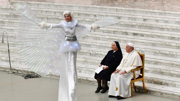Pope Francis and Suor Antonietta Collacchi, director of the Santa Marta dispensary, look at a performer on stilts during an audience for children and families of the Santa Marta dispensary, at Paul-VI hall, in the Vatican. (Vincenzo Pinto / AFP) Pope Francis and Suor Antonietta Collacchi, director of the Santa Marta dispensary, look at a performer on stilts during an audience for children and families of the Santa Marta dispensary, at Paul-VI hall, in the Vatican. (Vincenzo Pinto / AFP)