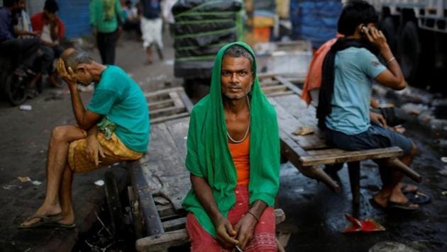 Migrant labourers sit on a handcart as they wait for work at a wholesale market in the old quarters of Delhi.(Photo: Reuters) Migrant labourers sit on a handcart as they wait for work at a wholesale market in the old quarters of Delhi.(Photo: Reuters)