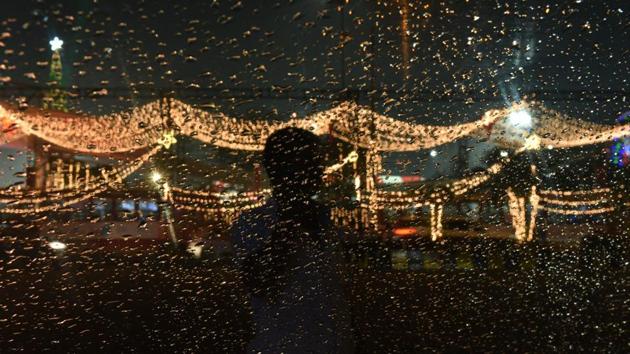A person is silhouetted as raindrops are seen on a glass, at Bandra Kurla Complex,Bandra, in Mumbai, Maharashtra. (Pramod Thakur / HT Photo)