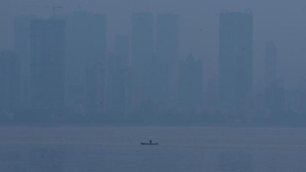 A man rows a boat as smog shrouds the city skyline, at Worli in Mumbai, Maharashtra. (Pramod Thakur / HT Photo)