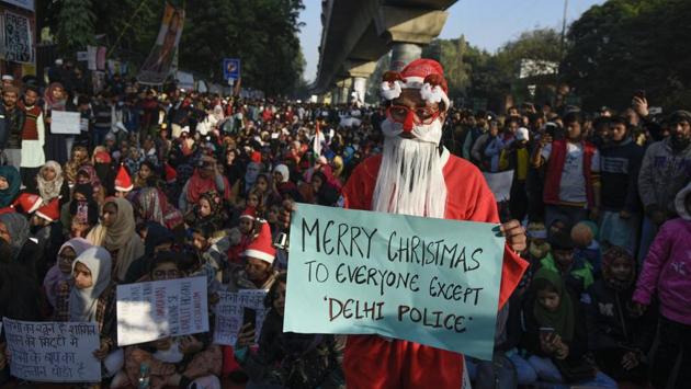 A man dressed as Santa Claus holds a placard during the 11th straight day of protest against CAA and NRC, outside Jamia Millia Islamia, Maulana Mohammad Ali Jauhar Marg, in New Delhi. (Burhaan Kinu / HT Photo)