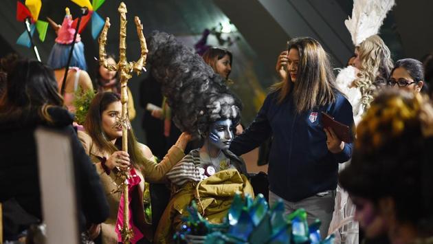 A participant is surrounded by people during the Make-up and Hair World Championship at Talkatora Stadium in New Delhi. (Sanchit Khanna / HT Photo)