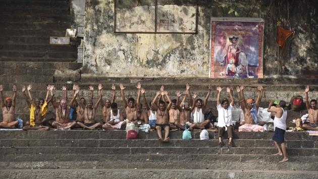 Devotees pray during partial solar eclipse at Banganga Tank, Walkeshwar Temple, in Mumbai, Maharashtra. (Anshuman Poyrekar / HT Photo)