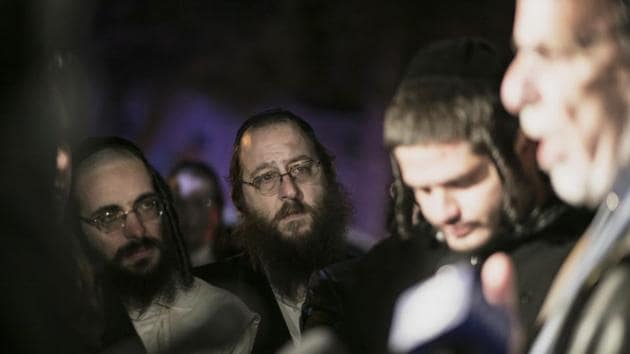 Orthodox Jewish people listen to N.Y. state Assemblyman Dov Hikind speak in Monsey, N.Y., Sunday, Dec. 29, 2019, following a stabbing late Saturday during a Hanukkah celebration. A man attacked the celebration at a rabbi's home north of New York City late Saturday, stabbing and wounding several people before fleeing in a vehicle, police said.(AP) Orthodox Jewish people listen to N.Y. state Assemblyman Dov Hikind speak in Monsey, N.Y., Sunday, Dec. 29, 2019, following a stabbing late Saturday during a Hanukkah celebration. A man attacked the celebration at a rabbi's home north of New York City late Saturday, stabbing and wounding several people before fleeing in a vehicle, police said.(AP)