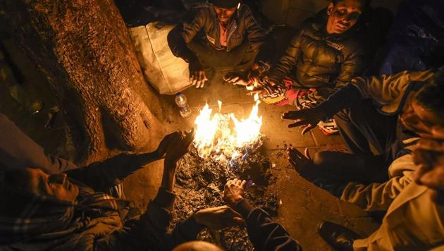 Workers warm themselves at a bonfire on a cold winter in in New Delhi on Saturday, Dec. 28, 2019.(PTI file photo)