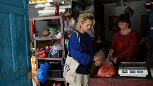 Chen Yan shops for vegetables at a grocery store in Guandong village close to where the alternative lifestyle community is located. (Tingshu Wang / REUTERS)