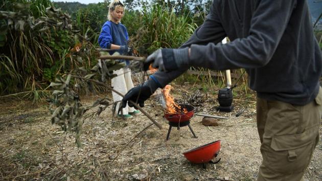 Chen Yan and Yang Zhaoyu burn branches and weeds to make plant ash which is used to cover faeces in an ecological toilet at AnotherCommunity. It is now opening to the public for a four-month trial. Since mid-October, over 20 potential residents -- from former computer programmers to online English teachers and freelance videographers have signed up to join the community. (Tingshu Wang / REUTERS)