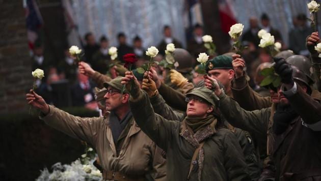 Actors hold up flowers as they perform during a ceremony to commemorate the 75th anniversary of the Battle of the Bulge at the Mardasson Memorial in, Belgium on 16 December.(AP Representational Photo)