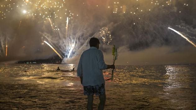 A man takes an offering to Yemanja, as fireworks explode over Copacabana Beach during the New Year's celebrations, in Rio de Janeiro, Brazil. (Bruna Prado / AP) A man takes an offering to Yemanja, as fireworks explode over Copacabana Beach during the New Year's celebrations, in Rio de Janeiro, Brazil. (Bruna Prado / AP)