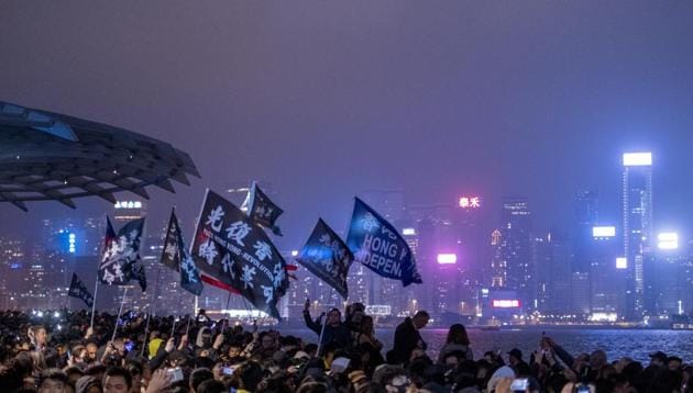 Demonstrators wave flags as they gather for a New Year's Eve countdown event in the Tsim Sha Tsui district of Hong Kong, China, on 31 December 2019.(Bloomberg Photo)