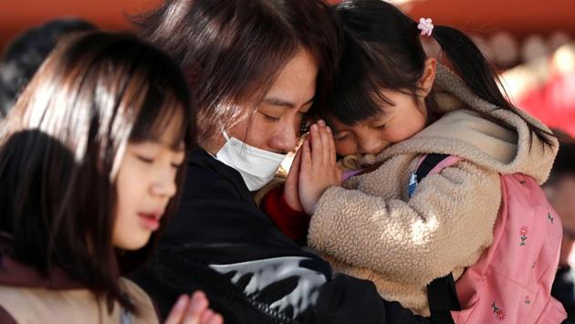 A family members offers prayers on the first day of the new year at the Meiji Shrine in Tokyo, Japan. (Issei Kato / REUTERS) A family members offers prayers on the first day of the new year at the Meiji Shrine in Tokyo, Japan. (Issei Kato / REUTERS)
