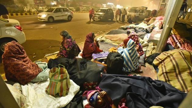 People spending the night near a bus shelter near AIIMS, in New Delhi. Last week, as the city shivered at 2.4°C— lowest minimum temperature since 1996— and Delhiites put on extra layers, a large number of homeless people were forced to brave the cold by sleeping out in the streets, like always. (Sanjeev Verma / HT Photo) People spending the night near a bus shelter near AIIMS, in New Delhi. Last week, as the city shivered at 2.4°C— lowest minimum temperature since 1996— and Delhiites put on extra layers, a large number of homeless people were forced to brave the cold by sleeping out in the streets, like always. (Sanjeev Verma / HT Photo)